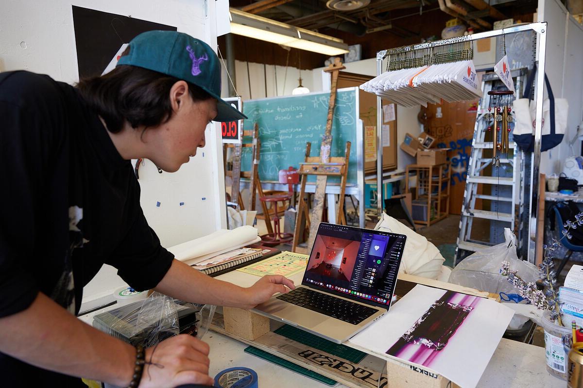 A student in an art studio working on a computer