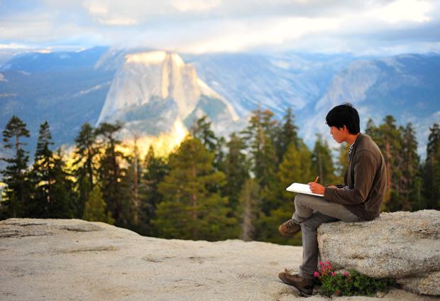 一个人坐在优美的优胜美地风景中写作