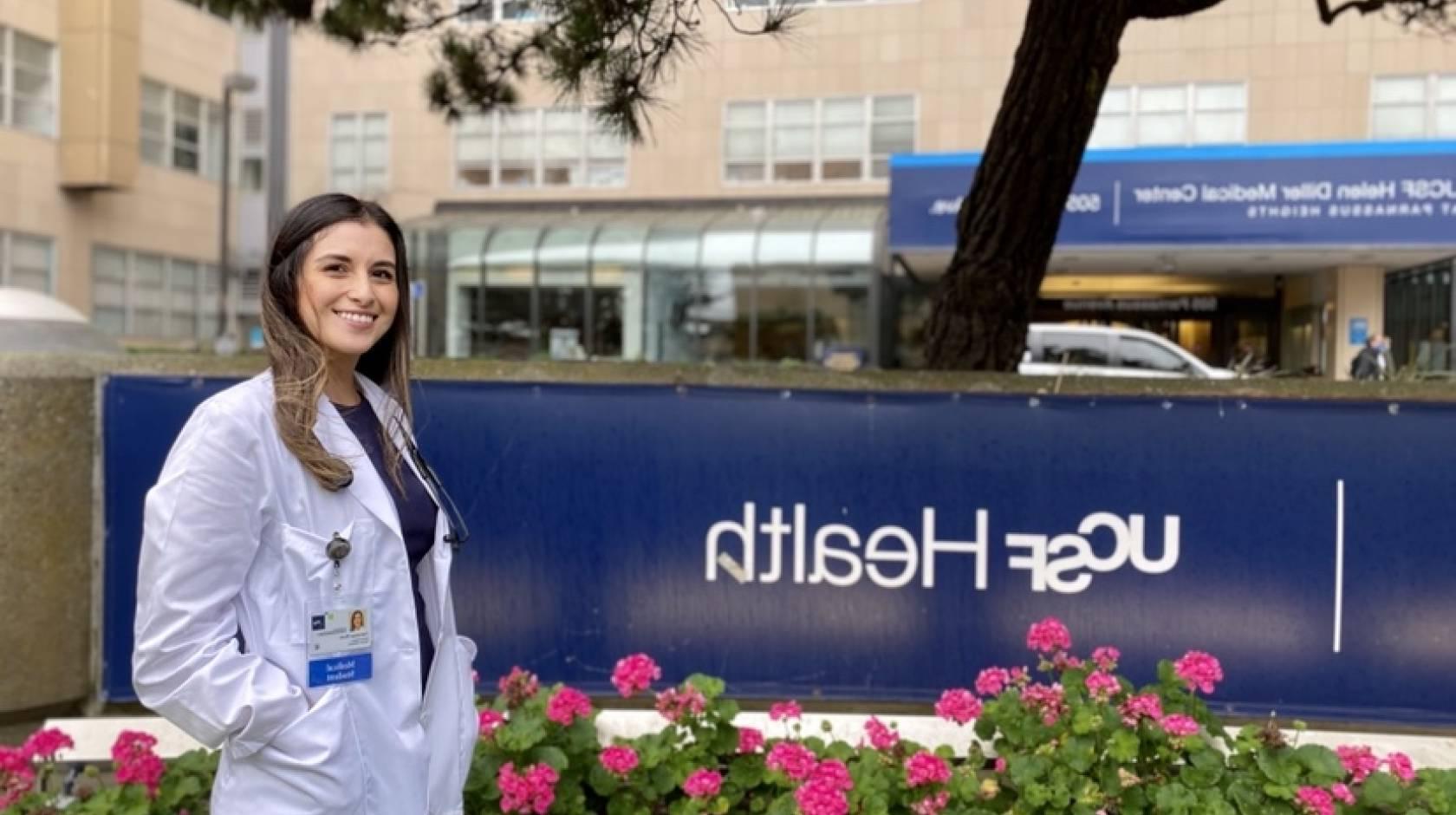 Vanessa Mora in a white coat in front of UCSF 健康 sign
