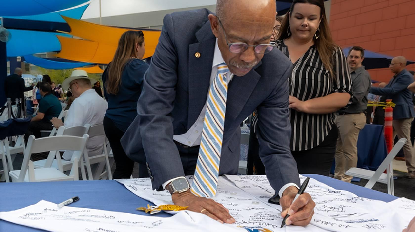 UC President Michael V. Drake M.D. signs a white coat