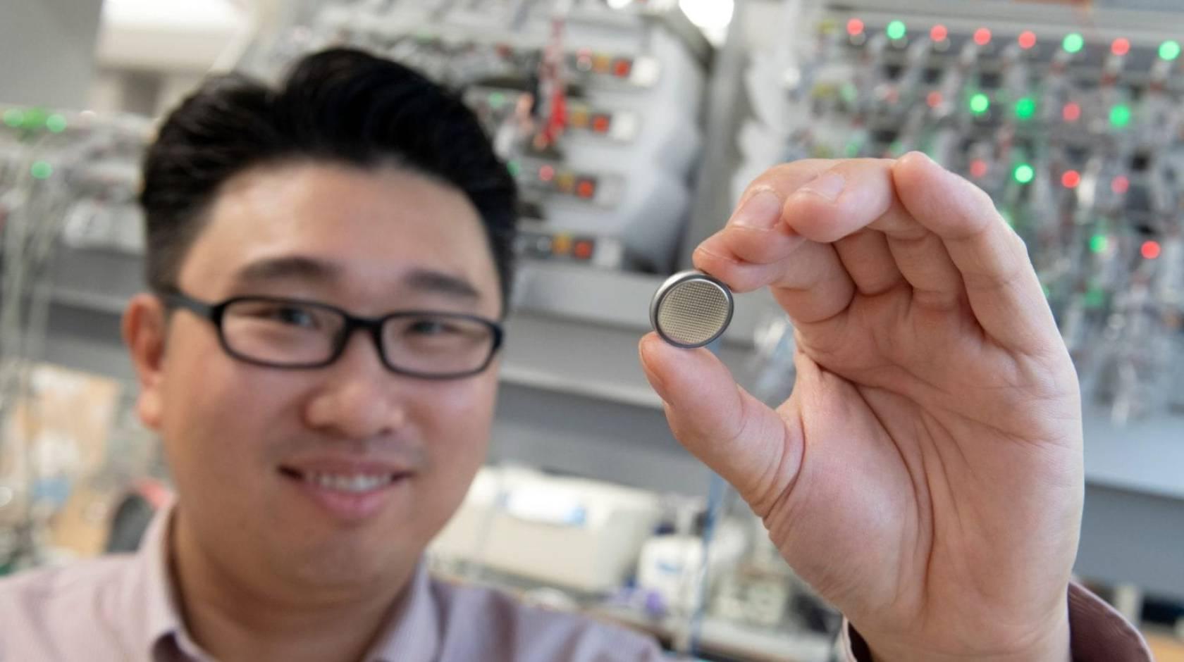 Huolin Xin, UC Irvine professor of physics & astronomy, holds up a small battery