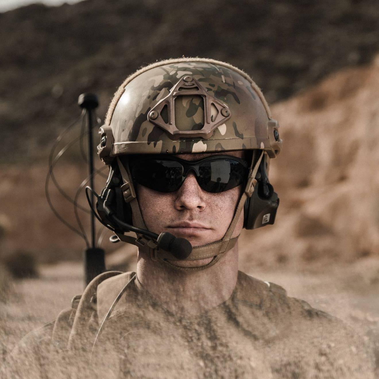 一个戴着墨镜，穿着军装的人，在沙漠里
