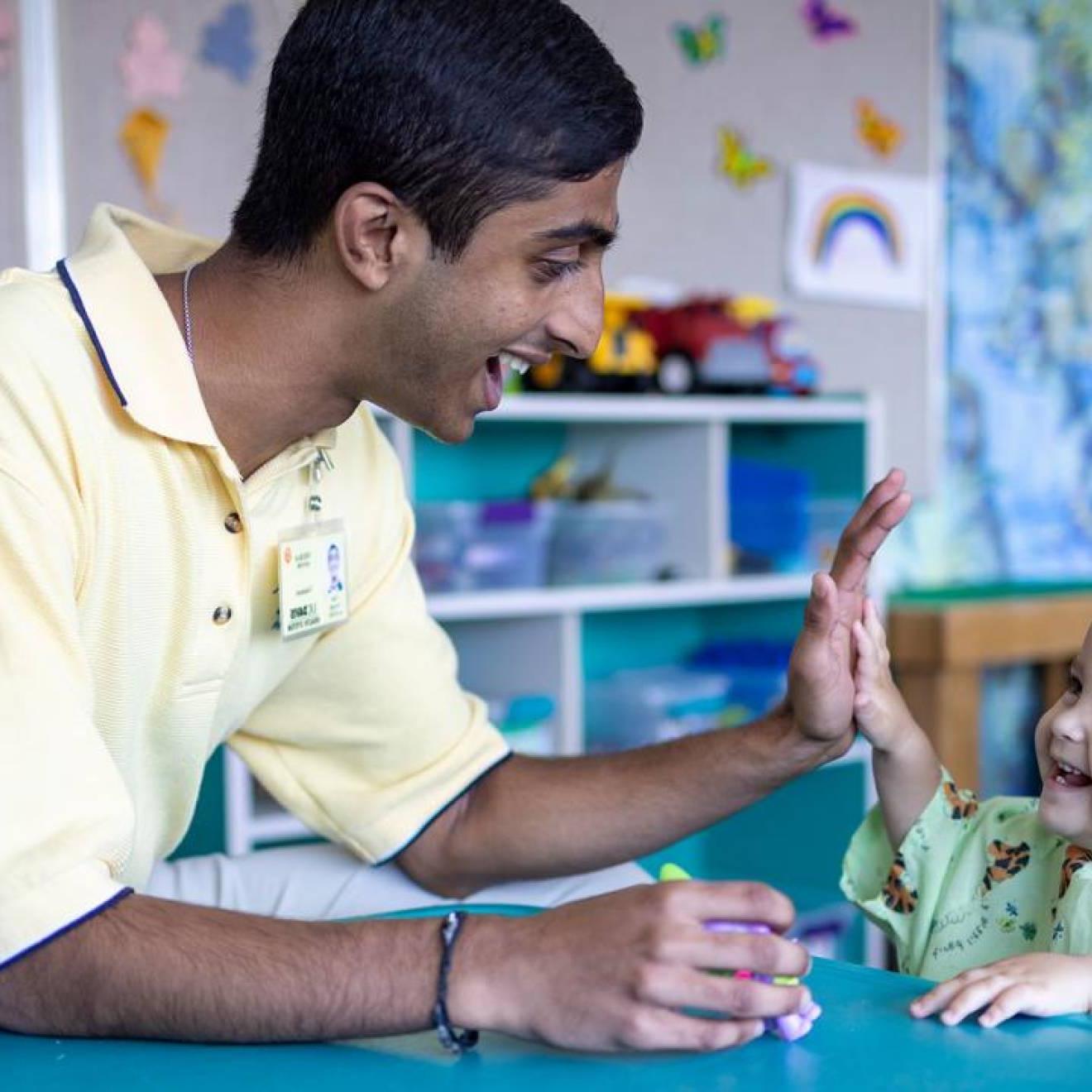 Neeraj Senthil在儿童医院与一个笑着的婴儿击掌