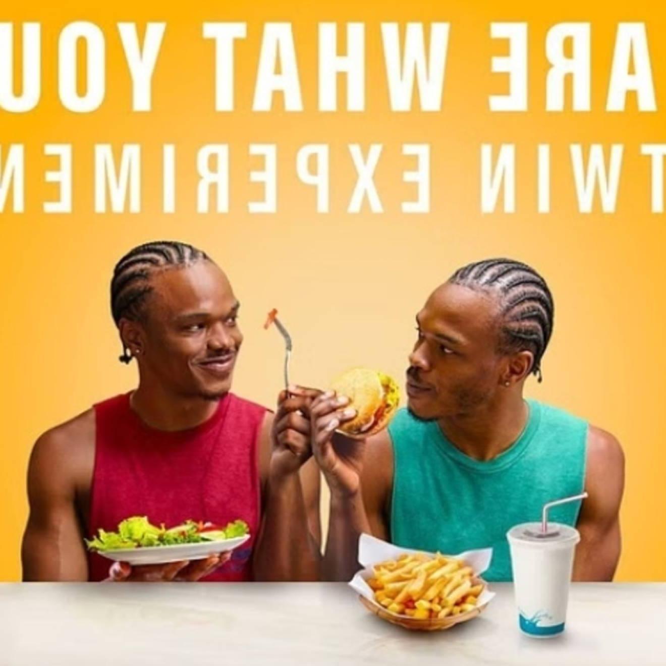 A photo of two young African American men, twins, one eating fast food and the other eating a salad